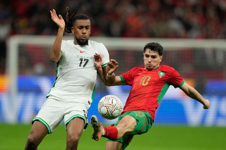Nigeria's Alex Iwobi , left, and Morocco's Brahim Abdelkader Díaz fight for the ball during the Africa Cup of Nations semi-final match between Nigeria and Morocco in Rabat, Morocco, Wednesday, Jan. 14, 2026. (AP Photo/Mosa'ab Elshamy)
